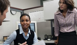 image of 3 people talking in an office cubicle